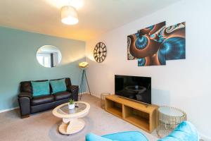 a living room with a couch and a tv at Derby Wilson Ave - Spacious 2 Bedroom Apartment with Garden in Derby