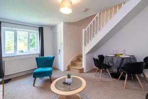 a living room with a table and chairs and a staircase at Derby Wilson Ave - Spacious 2 Bedroom Apartment with Garden in Derby