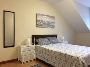 1 dormitorio con cama, tocador y espejo en Encanto Asturiano, 