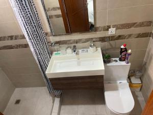 a bathroom with a sink and a toilet and a mirror at Modern 2 bedroom apartment in Sakumono-Tema Beach Rd, Accra-Ghana in Accra