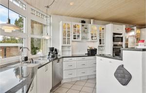 una cocina con armarios blancos y fregadero en 4 Bedroom Beautiful Home In Brande, en Brande