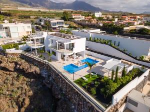 an aerial view of a white house with a cliff at Villa Andrea, quiet luxury, sunset with sea views in Adeje