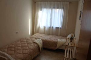 Habitación pequeña con cama y ventana en Encanto Mediterráneo with Airco, en Oliva