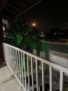 a balcony with a white railing and a palm tree at night at CasaparkIndaiatuba in Indaiatuba
