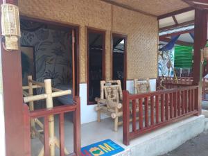 a front porch of a house with a wooden fence at Black Sweet Bungalow in Gili Islands