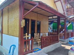 a house with a porch and a balcony at Black Sweet Bungalow in Gili Air