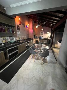 a dining room with a table and chairs and a bar at CasaparkIndaiatuba in Indaiatuba