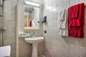 een badkamer met een wastafel, een toilet en een spiegel bij Giongo Residence Aparthotel 101 in Lavarone +20 foto's