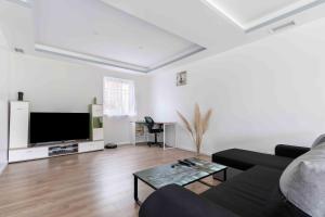 ein Wohnzimmer mit einem Sofa und einem Flachbild-TV in der Unterkunft Maison duplex 3 chambres à 6km de Bordeaux centre in Floirac
