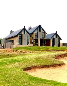 a large house on a field with a house at VAAL DE GRACE golf estate The SHACK in Parys