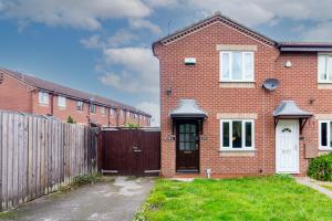 a red brick house with a wooden fence at Derby Wilson Ave - Spacious 2 Bedroom Apartment with Garden in Derby