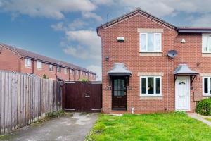 een rood bakstenen huis met een houten hek bij Derby Wilson Ave - Spacious 2 Bedroom Apartment with Garden in Derby