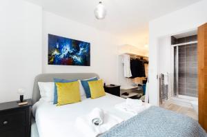 sypialnia z łóżkiem z żółtymi i niebieskimi poduszkami w obiekcie Stylish 2 BR Flat in Wandsworth w Londynie