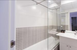 Un baño blanco con ducha y lavabo. en TGH Gran Vía Apartments, en Madrid 34 fotos más