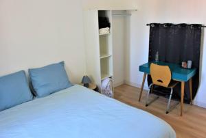 a bedroom with a blue bed and a desk at Magnifique appartement in Le Havre