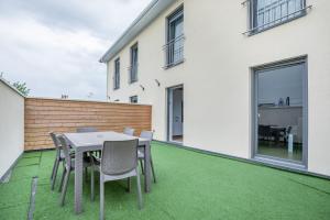 une terrasse avec une table et des chaises sur une pelouse dans l'établissement Maison duplex 3 chambres à 6km de Bordeaux centre, à Floirac