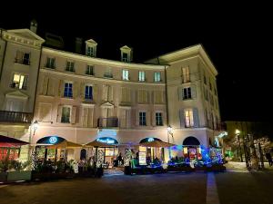a large white building with a store front at night at Appt Vue Place de Toscane - 4min Disneyland-PARIS in Serris