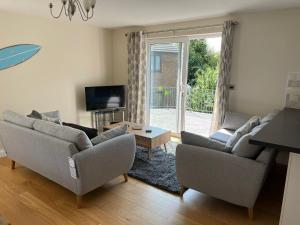 a living room with two couches and a tv at Berllan Deg in Cardigan