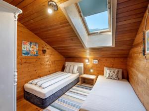 カルテンバッハにあるHaus Sabine Brauneggerのベッド2台と窓が備わる小さな屋根裏部屋です。