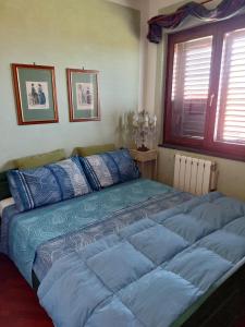a bedroom with a large bed with blue sheets at Casa Delle Coccole in Trecastagni