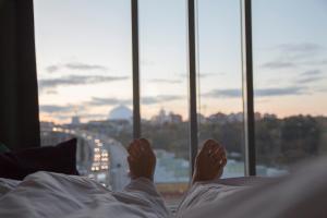 eine Person, die im Bett liegt, mit den Füßen auf einem Kissen in der Unterkunft Clarion Hotel Stockholm in Stockholm