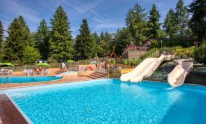 a swimming pool with a water slide in a playground at Glamping Payrac in Payrac