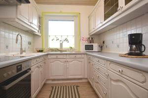 a kitchen with white cabinets and a window at BA02-RI Apartment bei Bamberg in Reckendorf