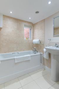 a white bathroom with a tub and a sink at Eyre arms 