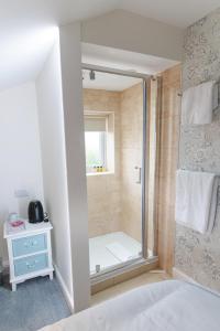 - une douche avec une porte en verre dans la chambre dans l'établissement Eyre arms, 