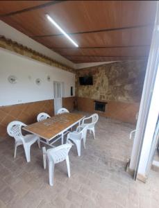 uma sala de jantar com uma mesa de madeira e cadeiras brancas em Casa rural el castillo em La Puebla de los Infantes