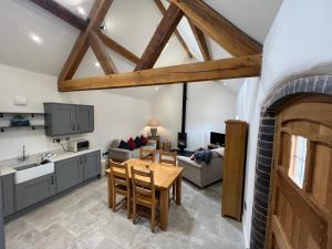 a kitchen and living room with a table and chairs at The Little Dairy in Stourbridge