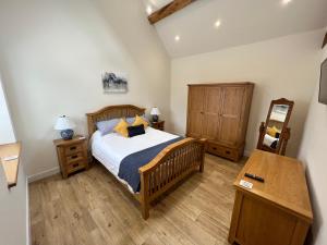 a bedroom with a bed and a dresser and a table at The Little Dairy in Stourbridge