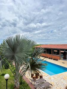 a villa with a swimming pool and a house at Pousada Hilário in São João del Rei