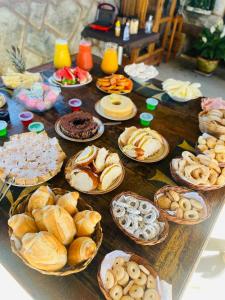 uma mesa com vários tipos diferentes de pastelarias em Pousada Hilário em São João del Rei