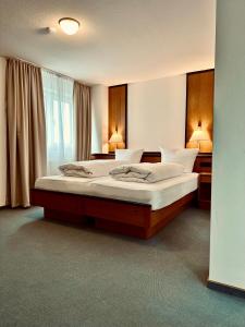 E&D Hotel Rodgau في رودغاو: غرفة نوم بسرير كبير ونافذة
