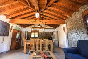 un soggiorno con soffitto in legno, tavolo e sedie. di La Higuerita ONLY FAMILES a Vilaseca de Solcina