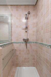 y baño alicatado con ducha y lavabo. en GuestReady - Trendy residence near Plaza Mayor, en Madrid
