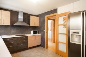 a kitchen with wooden cabinets and a refrigerator at EnjoyGranada ARCOIRIS in Granada