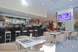 um restaurante com mesas e cadeiras e um bar em Hotel Best Andorra Center em Andorra-a-Velha