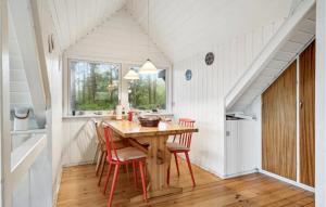 ØrbyにあるNice Home In Knebel With 3 Bedrooms And Wifiのダイニングルーム(木製テーブル、赤い椅子付)