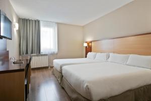 a hotel room with two beds and a television at Hotel Best Andorra Center in Andorra la Vella