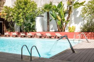 a large swimming pool with chairs and a pool at ALEGRIA Plaza Paris 4*Sup in Lloret de Mar