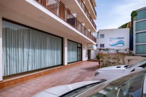 two cars parked in front of a building at Hotel Moremar by ALEGRIA in Lloret de Mar