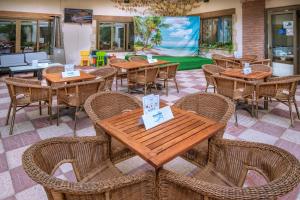 un restaurante con mesas y sillas de madera y una mesa de billar en Hotel Moremar by ALEGRIA, en Lloret de Mar