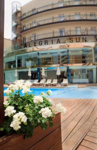 un hotel con piscina y un edificio en ALEGRIA Sun Village, en Lloret de Mar
