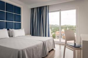 a hotel room with a bed and a large window at ALEGRIA Sun Village in Lloret de Mar
