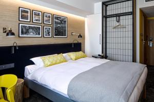 a bedroom with a large white bed with yellow pillows at B&B HOTEL Tomaszów Lubelski in Tomaszów Lubelski