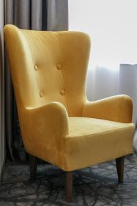 a yellow leather chair sitting in a room at B&B HOTEL Tomaszów Lubelski in Tomaszów Lubelski