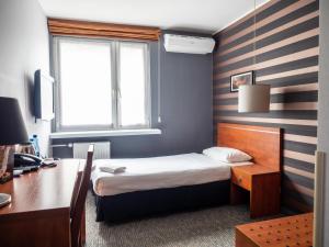 a bedroom with a bed and a desk and a window at B&B HOTEL Piotrków Trybunalski in Piotrków Trybunalski