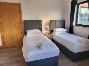 a room with two beds and a window at Wild Atlantic Apartments Port House Letterkenny in Letterkenny